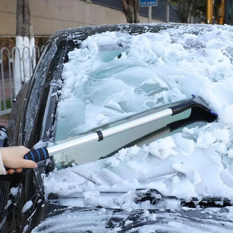 Eiskratzer schiebt Schnee von der Frontscheibe eines Autos