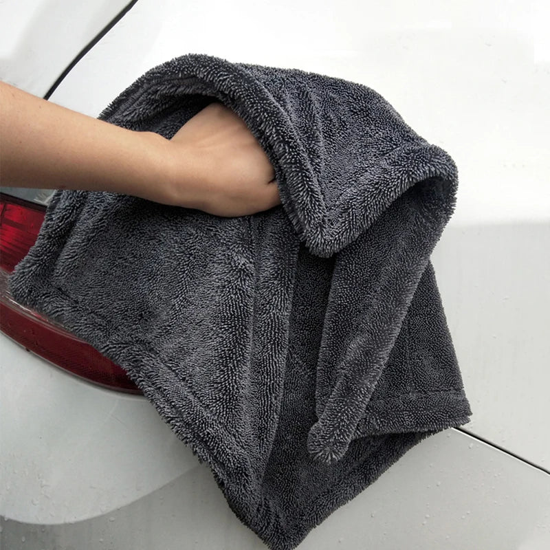 Graues Mikrofasertuch trocknet die Karosserie eines weissen Autos